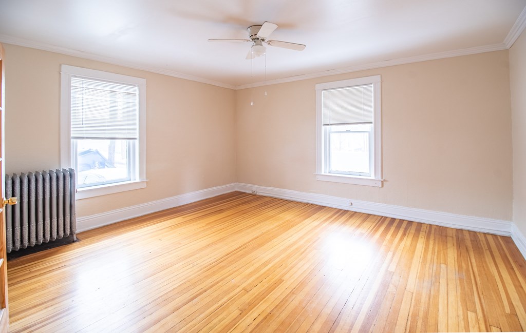 A room with wooden floors and a ceiling fan.