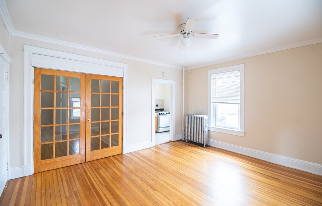 A room with a wood floor and a ceiling fan.