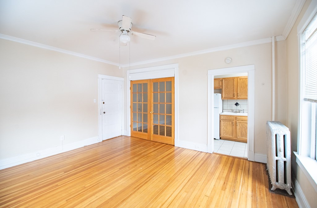 A room with a wooden floor and a ceiling fan.