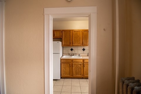 A kitchen with wooden cabinets and a white refrigerator.