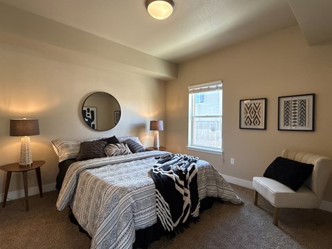 A bedroom with two beds and a chair.