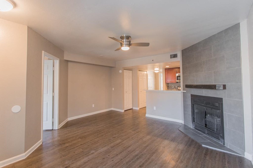 a living room with a fireplace and a ceiling fan