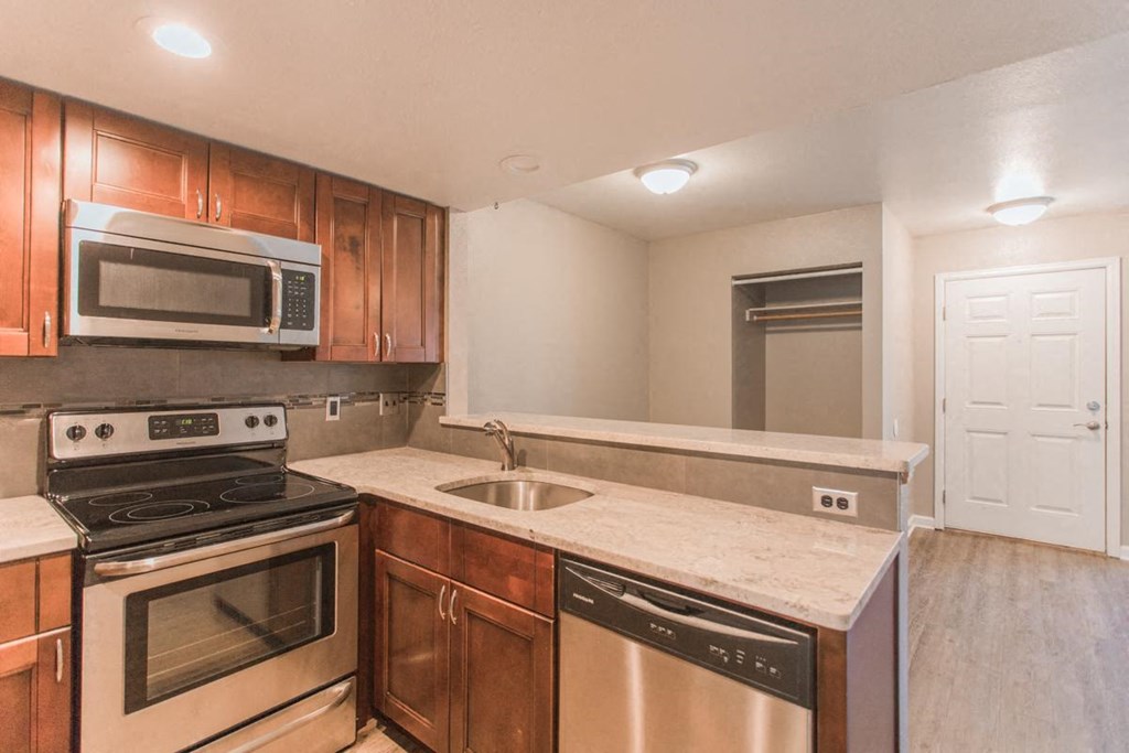a kitchen with stainless steel appliances and wooden cabinets