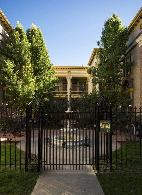 a wrought iron gate with a fountain in front of a building