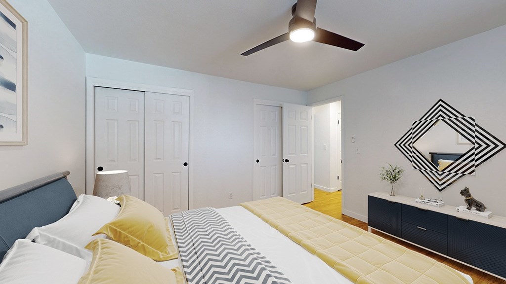A bedroom with a bed, dresser, and mirror.