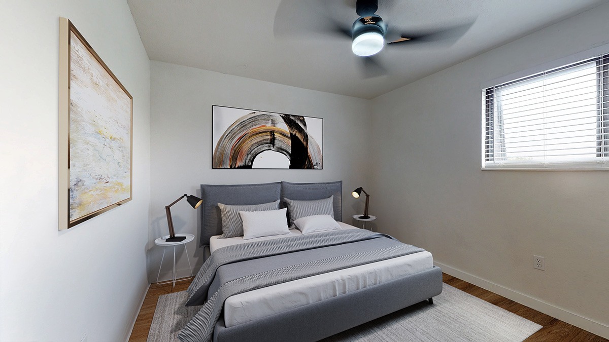 A bedroom with a large bed and a ceiling fan.