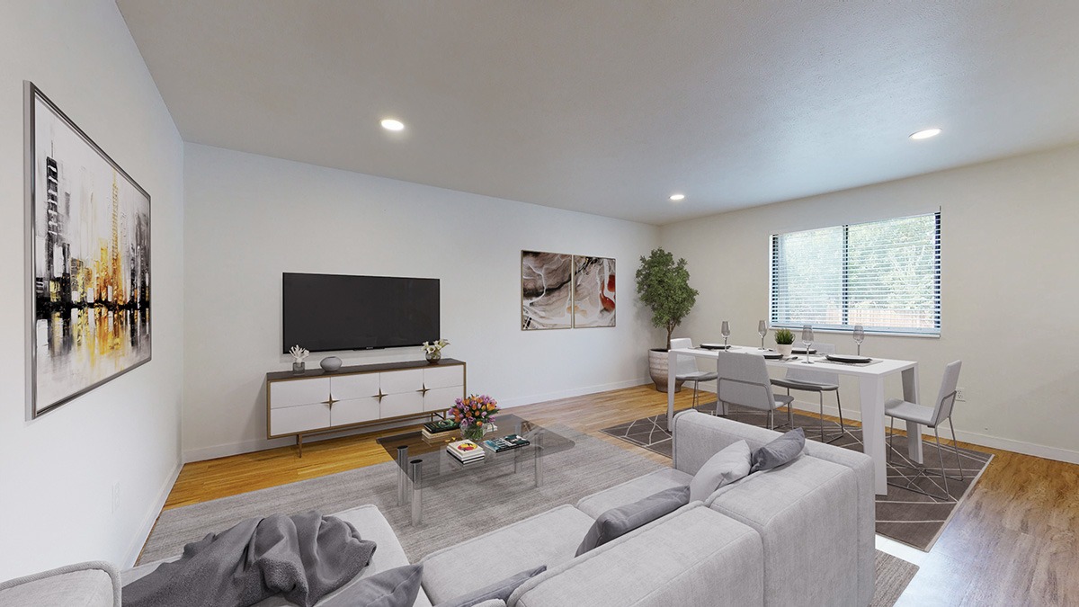 A living room with a grey couch and a white coffee table.