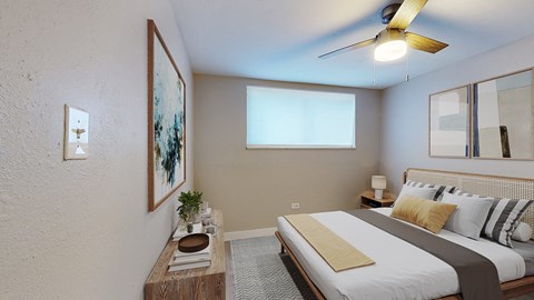 A bedroom with a bed, nightstand, and a ceiling fan.