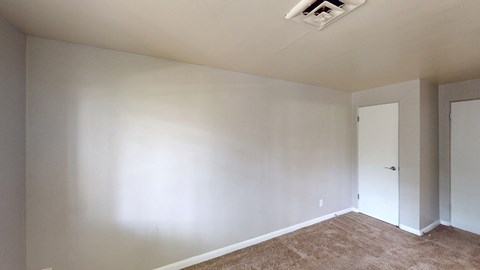 A room with white walls and carpeted floor.