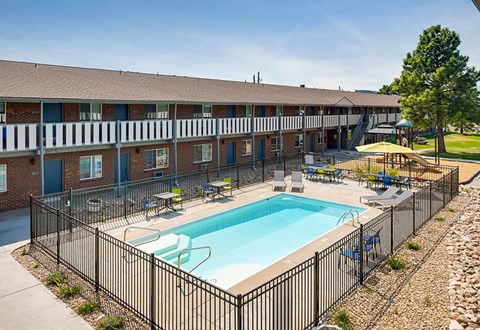 A black fence surrounds a small pool in front of a building.