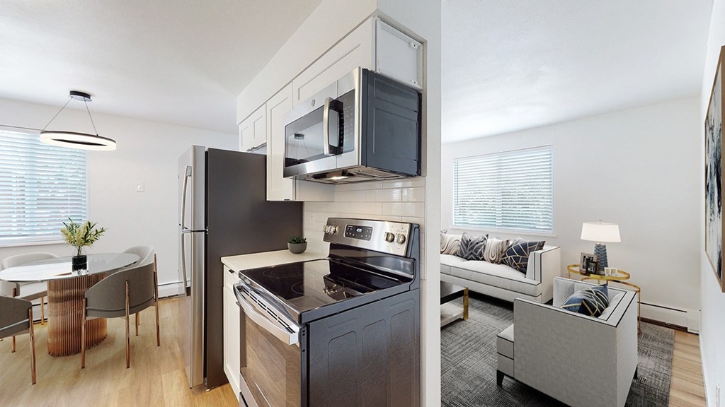 A modern kitchen with a black fridge and stove.