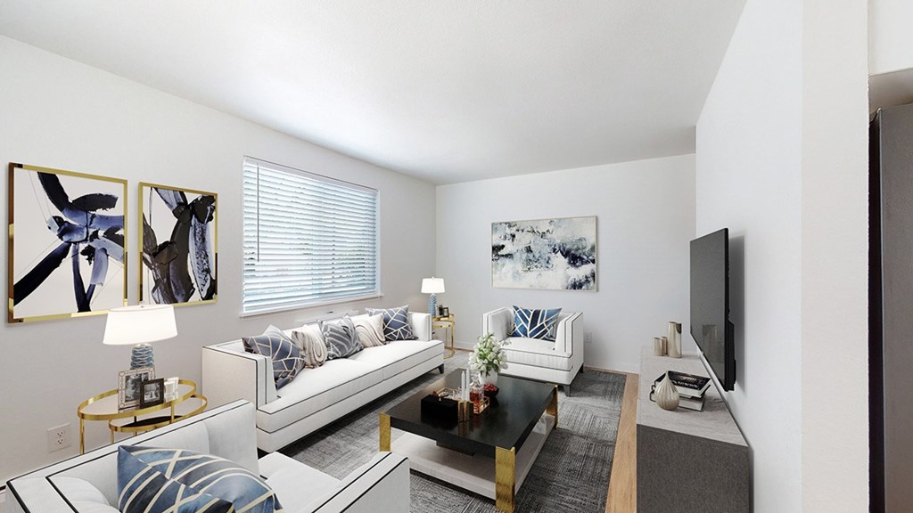 A living room with a white couch and a black coffee table.