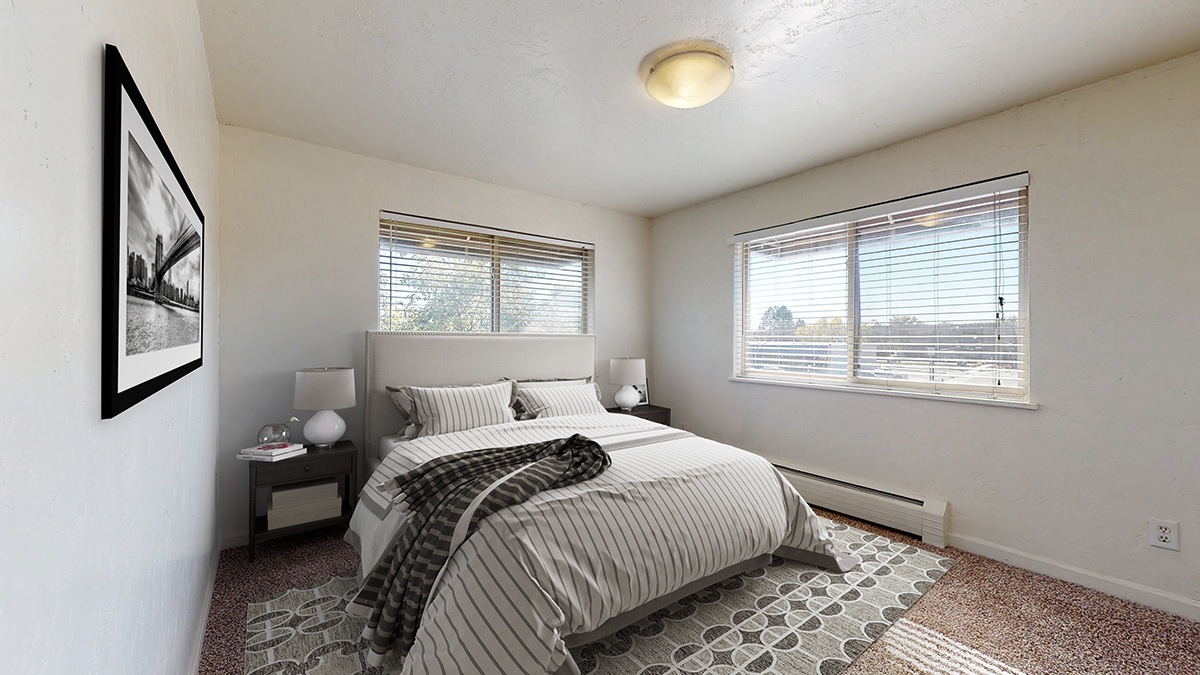 A bedroom with a bed, nightstand, and window.