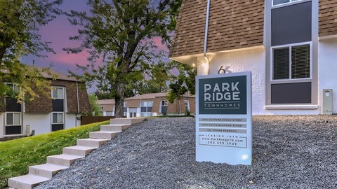 A sign for Park Ridge Townhomes stands in front of a building.