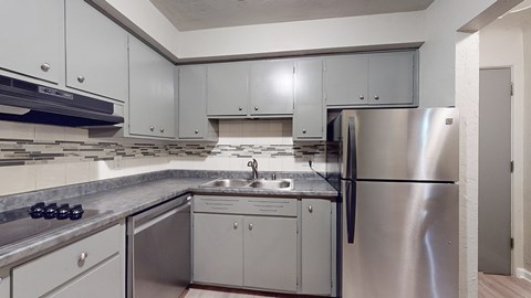 A modern kitchen with stainless steel appliances and white cabinets.