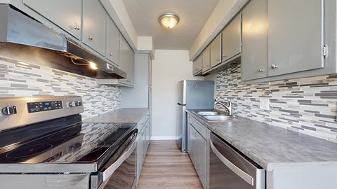 A modern kitchen with a stove top oven and a refrigerator.