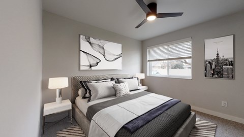 A bedroom with a large bed and a ceiling fan.