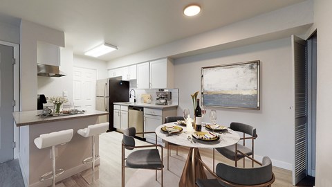 A modern kitchen with a dining table set for two.