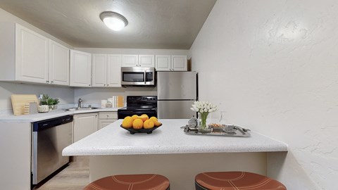 A kitchen with a table and chairs in the middle.
