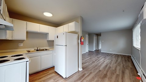A kitchen with white appliances and wooden floors.