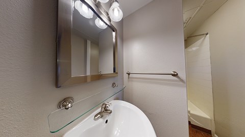 A white sink with a mirror above it.