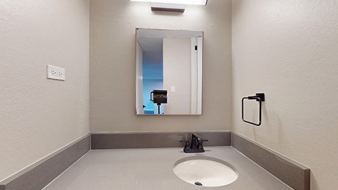A bathroom with a sink and mirror.