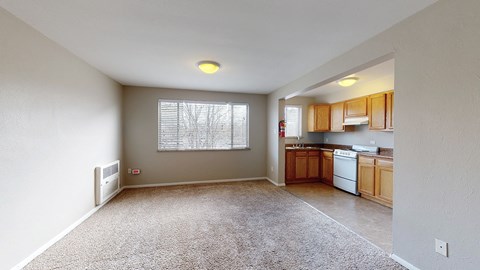 A spacious living room with a window and a carpeted floor.