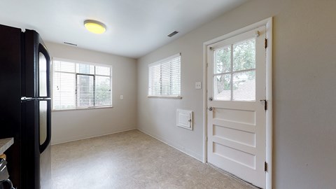A kitchen with a black fridge and a white door.