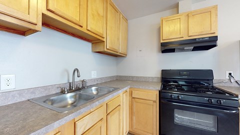 A kitchen with wooden cabinets and a black stove top oven.