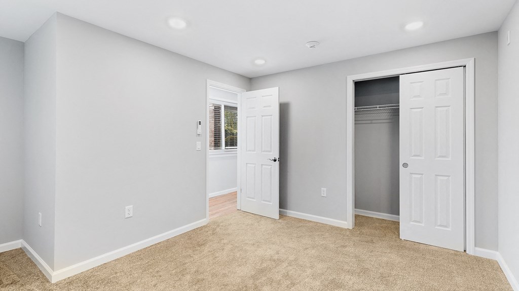 an empty room with two closets and a carpeted floor