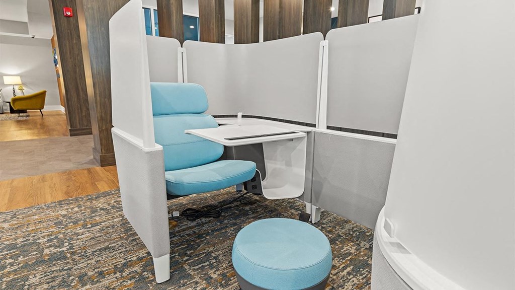 a meeting room with a blue chair and a desk