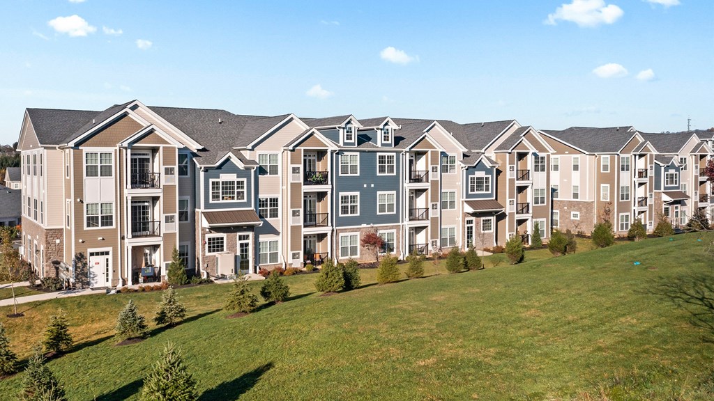 an exterior view of an apartment building on a hill