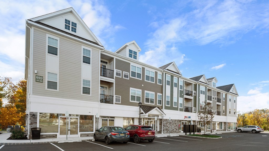 an apartment building with cars parked in front of it
