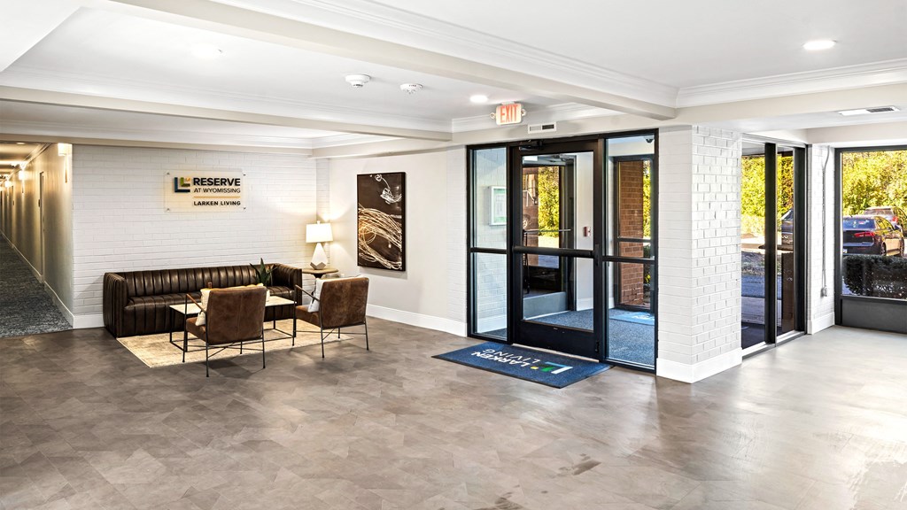a lobby with a couch and chairs and a door
