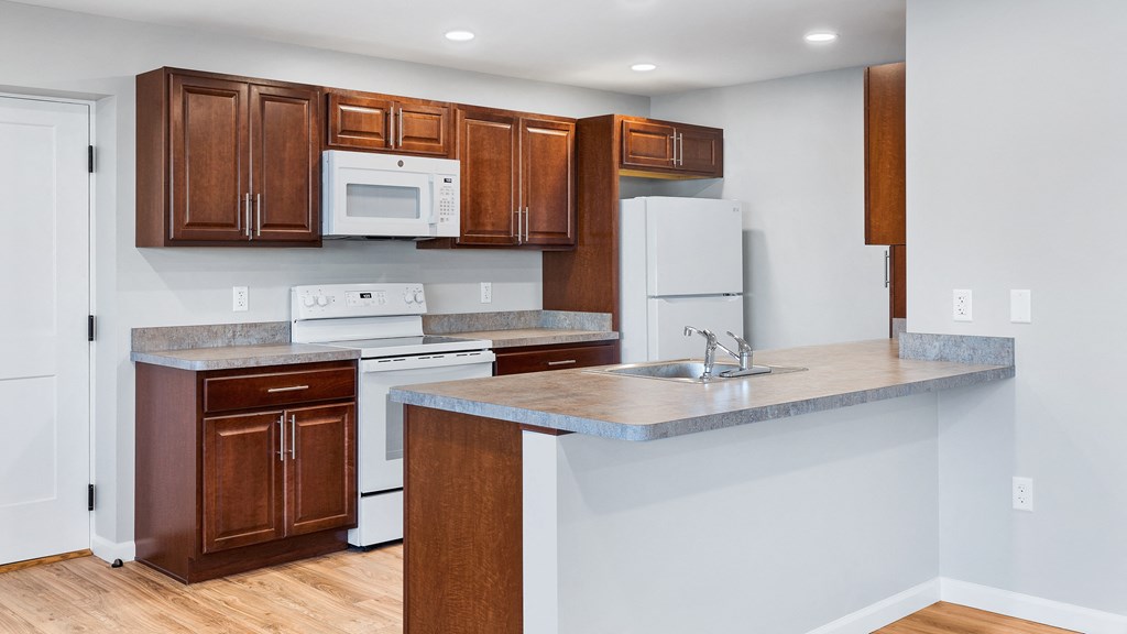 a kitchen with white appliances and wooden cabinets