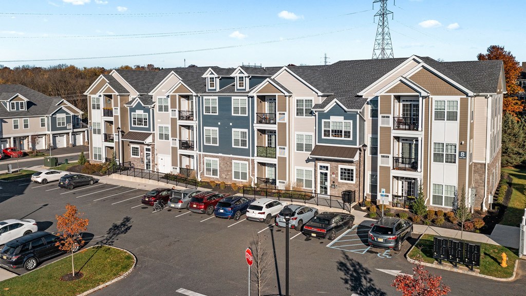 an aerial view of an apartment complex with cars parked in a parking lot