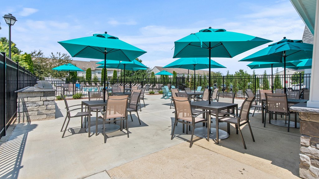 a patio with tables and chairs and umbrellas