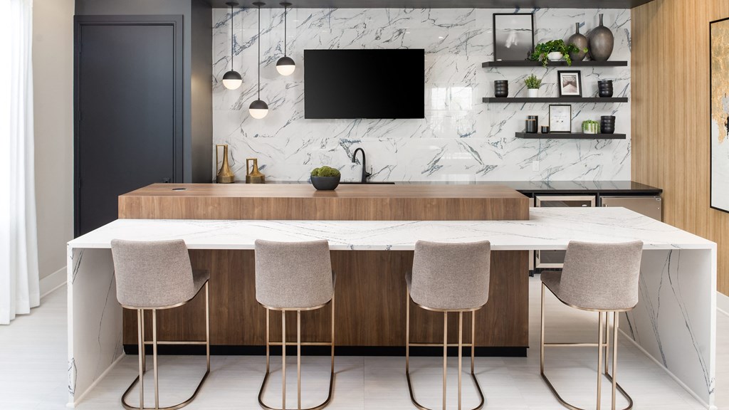 a kitchen with a marble counter top and four chairs
