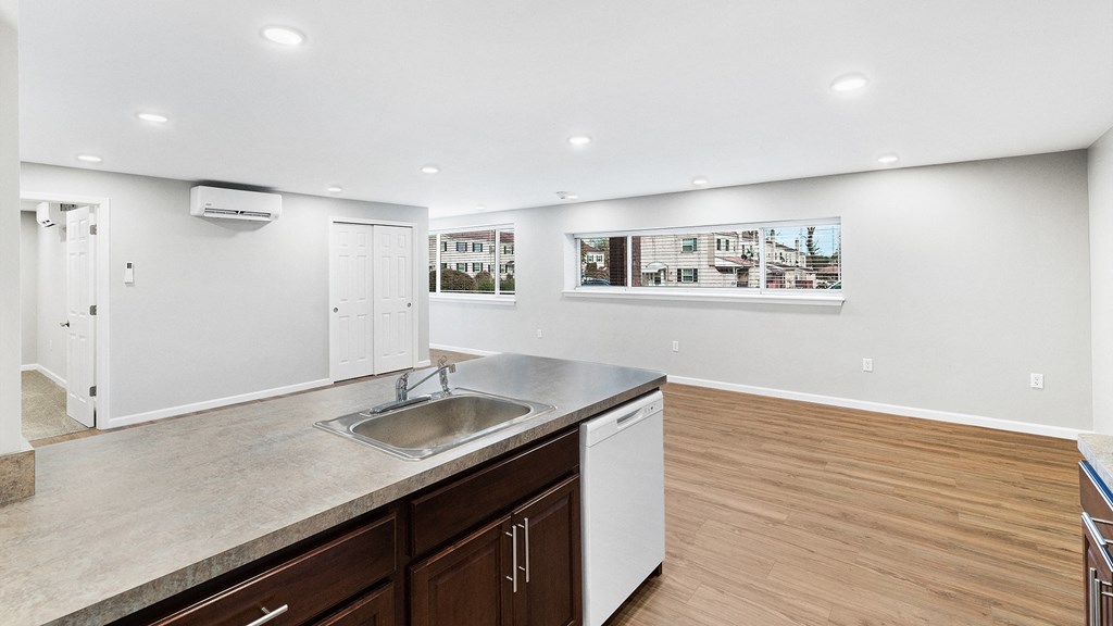 an empty kitchen and living room with a sink and a window
