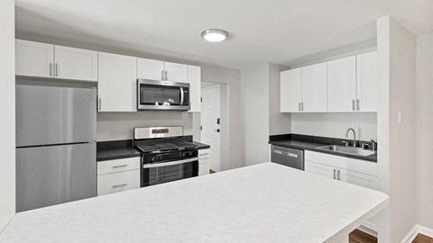 a kitchen with a white counter top and a refrigerator