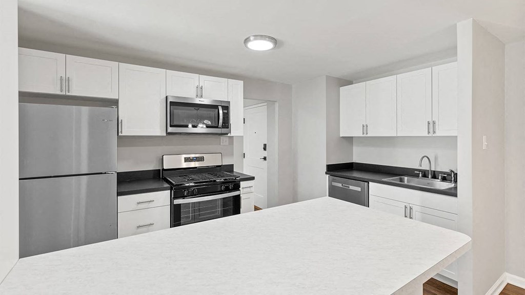a kitchen with a white counter top and a refrigerator