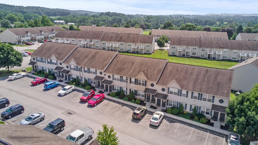 an aerial view of an apartment complex with cars parked in front