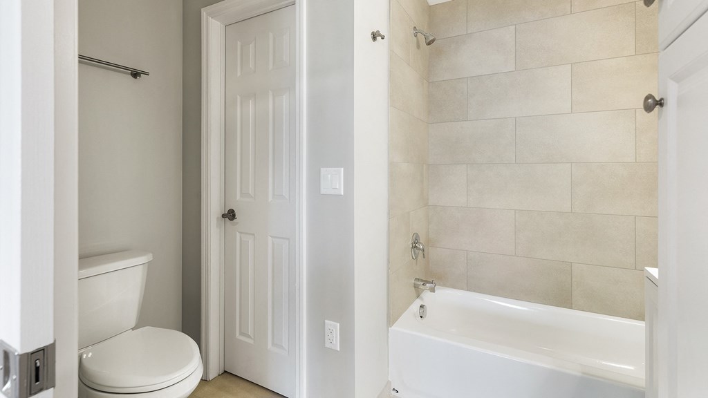 a bathroom with a white toilet and a tub and a sink