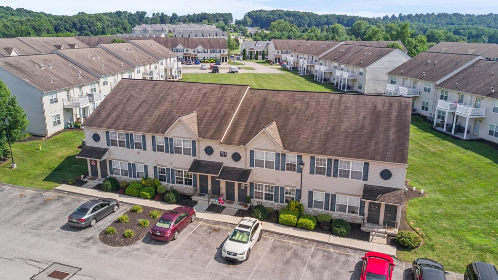 an aerial view of an apartment building with cars parked in front of it