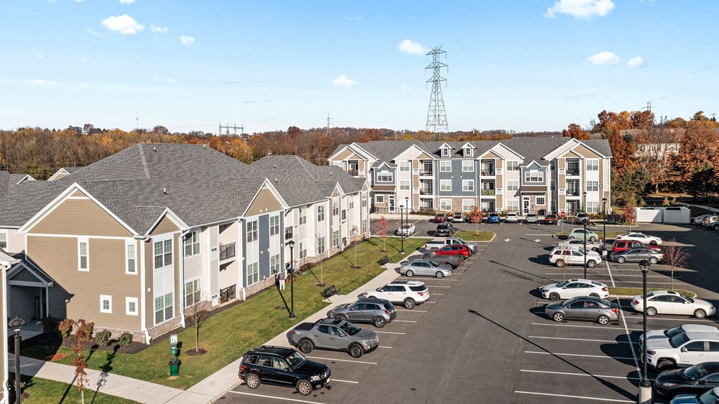 an aerial view of an apartment complex with cars parked in a parking lot