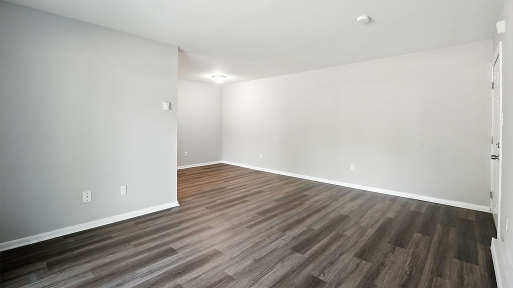 A room with wooden flooring and white walls.