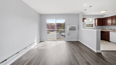 A spacious room with wooden flooring and white walls.