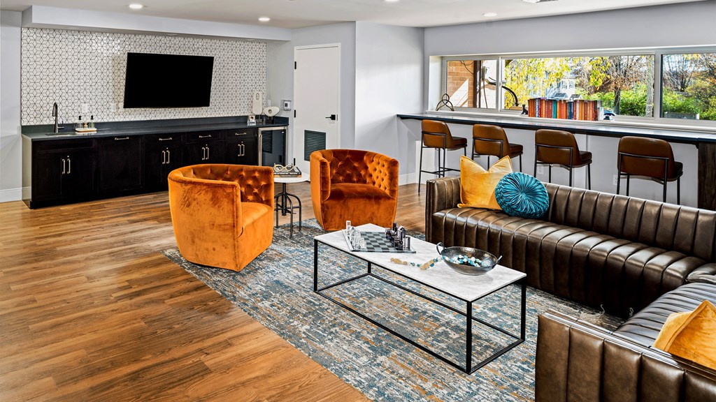 a living room with couches and chairs and a kitchen with a television