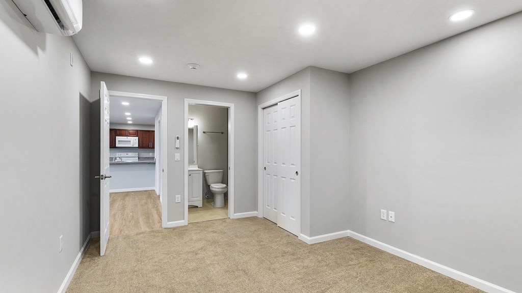 an empty room with a bathroom and a closet