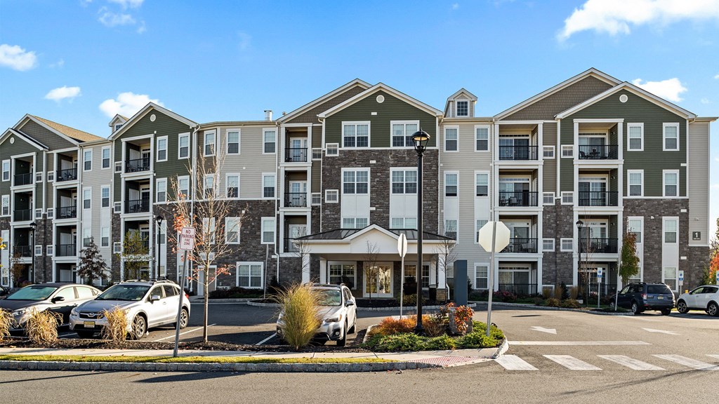 an apartment building on the corner of a street with cars